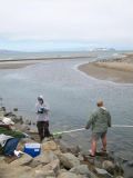 Water sampling the Crissy Marsh inlet to the San Francisco Bay, with Alcatraz Island seen in the background. The inlet is subject to periodic closure events, resulting from longshore sand migration and a muted tidal prism. Photo Credit: Hillary Harms, USGS