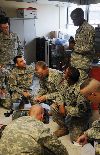 First Lt. Andrew Branch, right, standing, watches over his Soldiers and ROTC cadet Christopher Muse, second from right, as they conduct training at the 4th Sqdn., 4th Cav. Regt.’s aid station Aug. 2 at Fort Riley. Muse participated in the Cadet Troop Leader Training program for four weeks at Fort Riley and shadowed Branch, who is the medical services platoon leader. CTLT provides ROTC cadets from across the country an opportunity to experience leadership in units during a three- to four-week period.  Photo by:  Staff Sgt. Donald Martin, 1ST HBCT.