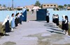 BAGHDAD, Iraq (Dec. 13, 2003) - Schoolgirls, waving ribbons and chanting a welcome, lined the walkway into the Ruqia Primary School, welcoming visitors on Nov. 15 the day of the grand reopening of the school. It is in the Abu Ghraib area of Baghdad.