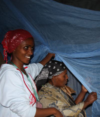 Women demontrating proper bed net usage