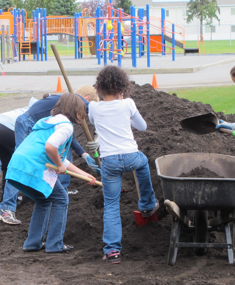 On the other side, students help create a schoolyard habitat with native trees and shrubs to attract migratory birds on to school grounds.  Photo Credit: K. Mueller/USFWS