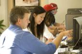 Row of teachers, students in computer lab