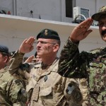 Brig. Gen. Aminullah Patyani (Right), commander of the Kabul Military Training Centre (KMTC), Col. Mike Minor (Middle), commander of KMTC Training Advisory Group (TAG), and Warrant Officer Richard J. Pyshorn (Left) , KMTC TAG Regimental Sgt. Maj. salute as the national flag of Afghanistan is raised at a special ceremony at Camp Alamo on the KMTC grounds, April 9.