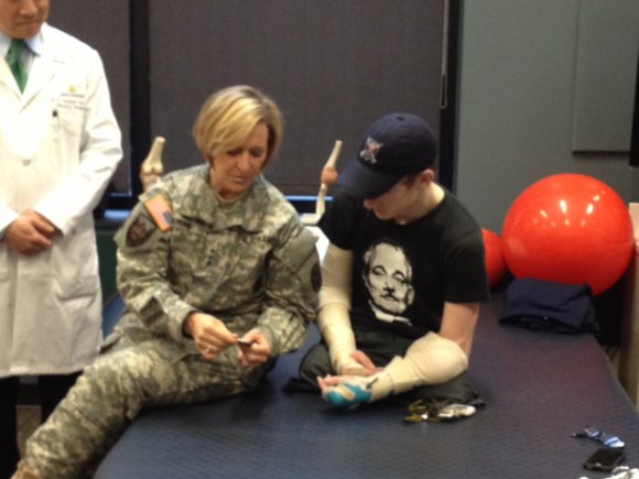 Lt. Gen. Patricia Horoho, Army Surgeon General, presents former Sgt. Brendan Marrocco with a coin during a short break in his physical therapy session, Feb. 11, 2013, at the Johns Hopkins University Hospital in Baltimore.  A coin and an inspiring key chain was provided, as Marrocco's goal is to one day be able to drive again.