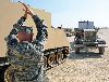 Sgt. Brandon Leamont, logistics noncommissioned officer, Troop D, 5th Sqdn., 4th Cav. Regt., left, ground guides a vehicle hauling a generator Aug. 9 at a motor pool at the Douthit Multi-Purpose Range Complex. Troop D assumed responsibility for logistics at the range complex Aug. 6 and will continuously provide fuel, ammunition, mail, food and other logistical factors through the end of August.  Photo by:  Sgt. Daniel Stoutamire, 2ND HBCT.