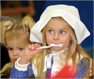 Dressed as a Pilgrim, a young girl enjoys a forkful of mashed potatoes at the Montessori Children’s Center in Wheeling, West Virginia.