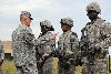 FORT RILEY, Kan.—Sgt. Maj. of the Army Raymond F. Chandler III, left, speaks to, from left, Cpl. Ebony Allen, Spc. Alphonsa Graves, and Spc. Isaac Evans, all with 1st “First Lightning” Battalion, 7th Field Artillery Regiment, 2nd Armored Brigade Combat Team Sep. 13 prior to presenting them with coins for outstanding service. During his visit to the battalion’s field exercise training area, Chandler spoke to Soldiers and senior leaders about their M1096 Paladin howitzer dry- and live-fire certifications. (U.S. Army photo by Sgt. Daniel Stoutamire)