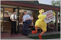 观看 Windows Media 格式的“鸡”宣传片。Every Door Direct Mail（挨门直邮）宣传片的截图，显示当邮差向餐厅经理投递邮件时，餐厅门口有一位身着鸡装的人举着标牌在舞动身姿。
