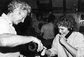 Director Leon Lederman pours champagne for Linda Klamp as she "spreads the news" on Sunday, July 3