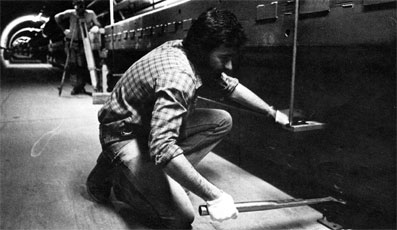 Gary Capola (kneeling) and Terry Guthke use surveying techniques to align a Doubler magnet to within a few thousandths of an inch