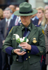 A CBP Border Patrol agent holds a vase of white roses to place on a wreath honoring the victims of 9/11.