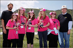 Photo of a group of female students wearing hot-pink t-shirts, smiling.