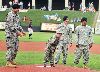 From left to right, Sgt. Marlon Alvarado, Spc. Josh Martin and Spc. Arthur Middlebrooks cheer on Ian Field, center, as he throws the first pitch at a recent Kansas City T-Bones Game July 29 in Kansas City, Kan.  