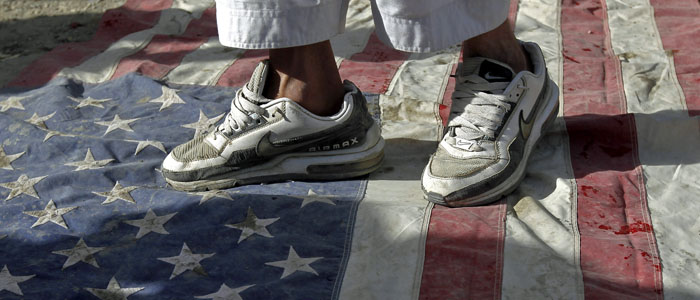 An Afghan protester steps on a U.S. flag during a demonstration in Kabul,