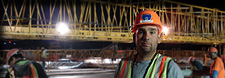 Photograph of Carlos Figueroa at a construction site wearing a hard hat.