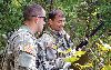 Spc. Sean Hall, left, and Warrant Officer 1 Gilberto Rosaldo, right, work with air assets via radio to coordinate their rescue pick up during evasion training Sept. 14 at Fort Riley.  Photo by: Sgt. Keven Parry, CAB.