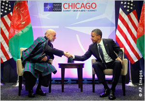 Hamid Karzai shaking hands with President Obama in front of U.S. and Afghan flags (AP Images)