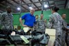 CAMP ARIFJAN, Kuwait (April 27, 2011) - Maj. Gen. Peter M. Vangjel, deputy commanding general of Third Army, guides the Honorable Thomas Lamont, assistant secretary of the Army for Manpower and Reserve Affairs, Department of the Army, through a warehouse of Army equipment, April 27. This equipment, known as rolling stock, is one of the many ways Third Army makes their logistical mission more cost-effective, making sustaining the Warfighter a more attainable goal for all Third Army assets. Photo by Spc. Eric Guzman, Third Army Public Affairs. VIRIN: 20110427-A-5706G-021