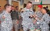 Lt. Col. Clyde Michael Buckley, 84th EOD battalion commander, second from left, prepares to cut the cake with the youngest of the “Crimson Talons,” Pvt. Kenneth Flint, as Chap. (Capt.) Jae Kim, right, and Soldiers look on during the unit’s Dec. 5 Christmas tree lighting ceremony. 