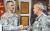 Brig. Gen. Donald MacWillie, senior commander, Fort Riley, right, presents Pfc. Nicholas Ward, fire direction specialist, HHB, 2nd Bn., 18th FA Regt., left, with a 1st Inf. Div. coin Aug. 17, in the battalion’s war room. Ward was the winner of the Fort Sill, Okla., Soldier of the Quarter.  Photo by: 75TH FIRES BDE.