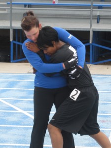 Airman Stacy Pearsall assists AW2 Soldier SPC Brittany Cosom across the finish line in the Women's 1500m.  Throughout the Warrior Games, athletes crossed the branches of service to celebrate accomplishments and support one another in pursuit of athletic achievement.