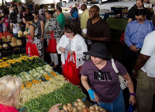 Agriculture Deputy Secretary Kathleen Merrigan (center, white jacket) buys produce at the Baltimore farmers market in Baltimore, MD., on July 8, 2012. The mid-Atlantic region saw double-digit growth in its listings in the National Farmers Market Directory.  Maryland added 76 new market listings alone. USDA Photo by Lance Cheung.