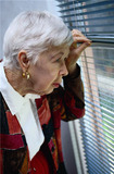 A worried woman peering out a window. - Click to enlarge in new window.