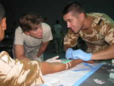 SGT Tammy Ellis supervises a Romanian Soldier during combat lifesaver training.