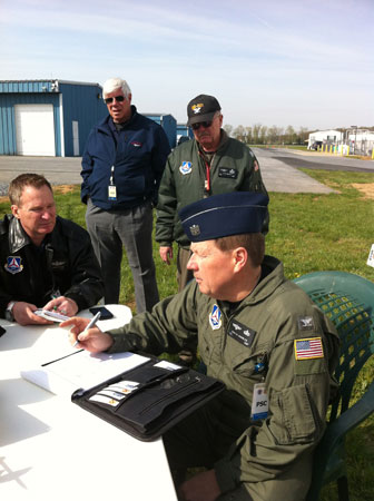 Col. Jerry Weiss (standing, right), CAP, observes and evaluates the planning session as Col. John Knowles (sitting, right), CAP briefs the planning staff during the search and rescue exercise that was held April 13.