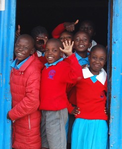 Seven school kids in uniform smiling for the camera