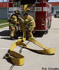 Photograph of two firefighters and a fire truck