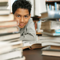 Joven estudiante entre pilas de libros