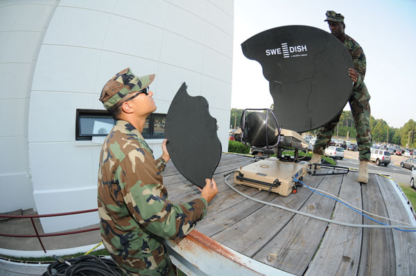 VIRGINIA BEACH, Va. (July 20, 2011) Information Systems Technician 2nd Class Michael Smith, assigned to Riverine Squadron (RIVRON) 3, and Operations Specialist 1st Class Robert McGill, assigned to Navy Expeditionary Combat Command, set up satellite communications equipment during Trident Warrior 2011 at Joint Expeditionary Base Little Creek-Fort Story. Trident Warrior is an annual fleet experiment focusing on new technology. U.S. Navy photo by Mass Communication Specialist 2nd Class Steven Hoskins.