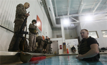 Sgt. Seth Handy, an instructor of water survival, prepares to demonstrate a gear drop exercise for Marines participating in a water survival swim qualification at Ramer Hall pool Jan. 12. In a situation where a Marine could drown, the Marine’s gear must be dropped within seconds to escape. The Marine Corps’ water survival program prepares Marines to survive possible life-threatening, situations in the water. 