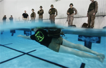 Sgt. Seth Handy, an instructor of water survival, demonstrates how to effectively swim with gear for Marines during a water survival qualification at Ramer Hall pool Jan. 12. Handy demonstrated different strokes Marines could use to complete that portion of the qualification. The Marine Corps’ water survival program gives Marines the skills to survive possible drowning situations such as going overboard a ship, during vehicle rollovers into a river or any other water-based emergency. 