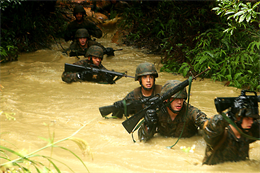 Marines with Battery B, 12th Marine Regiment, 3rd Marine Division, III Marine Expeditionary Force, navigate through waist-deep, foul-smelling water, toward their next obstacle during the endurance course portion of the jungle survival skills course at the Jungle Training Survival Center, Oct. 21. The artillery trained Marines became familiar with jungle survival skills by learning how to gather their own food, making fire from scratch, land navigation, combat patrolling, building an expedient shelter, and repelling.