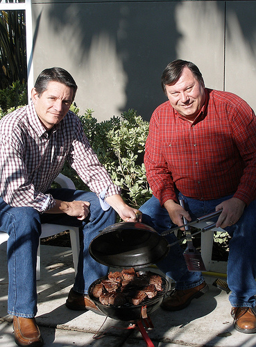 AMS Poultry Program employees Mark Perigen (left) and Gerald Brockman (right) prepare filet mignon on a tailgate-style grill.  They prefer a charcoal grill because of the smoky taste it offers.  Photo courtesy Mark Perigen