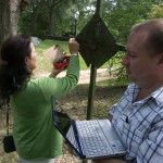 Carol Chin and Curtis Desselles use NCPTT's low cost eddy current analyzer to study an obscured inscription on an iron cross.