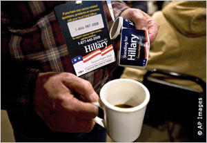 Close-up of hand carrying coffee and campaign stickers (AP Images)