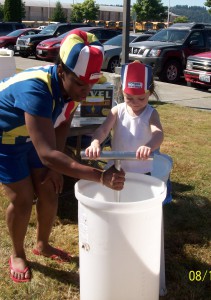 woman and child dipping stick in bucket