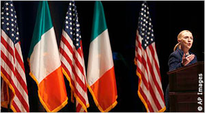 Hillary Rodham Clinton at podium with U.S. and Irish flags in background (AP Images)