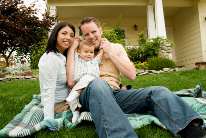 picture of family smiling in front of house