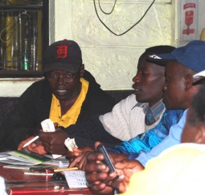 Members of the Bright View Self Help Group in Kawangware confirm cell phone payments during their weekly meeting