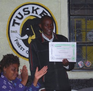 Man holding certificate and woman sitting down clapping