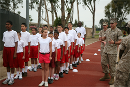 Cpl. Jonathan C. Beck, an F/A-18 mechanic for Marine Aviation Logistics Squadron 11, who volunteers as a drill instruntor for the recruits, instructs Young Marine recruits on proper bearing. The Young Marine recruits were in their third week of the two-month training cycle.