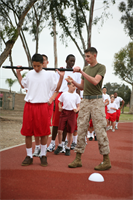 Lance Cpl. Michael A. Nibley, an administration clerk for Marine Wing Support Group 37, who volunteers as a drill instructor for the Young Marine recruits, leads physical training Saturday morining. The 'drill instructors' instill the Young Marine recruits with Corps values that shape them to be leaders of tommorow.