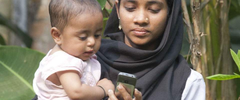 Bangladeshi mother and baby looking at mobile phone