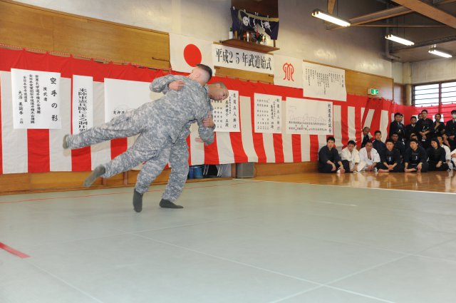 Staff Sgt. Matthew Prout, assigned to the 88th Military Police Detachment at Camp Zama, demonstrates modern Army combatives to Japanese police officers during the annual New Year's martial arts demonstration held Jan. 22 at the Sagamihara South Police Station.