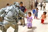 LUDIFIYAH, Iraq (June 12, 2008) - An Iraqi child gives a “high five” to a passing U.S. soldier from the 101st Airborne's 3rd Brigade Combat Team, which finished a meeting with the town's tribal leaders in Ludifiyah, Iraq, June 12, 2008. Photo by Spc. Richard Del Vecchio, U.S. Army.