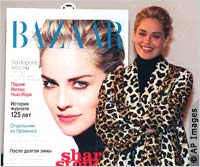 Actress Sharon Stone poses beside a poster of the first Russian edition of Harper’s Bazaar magazine.